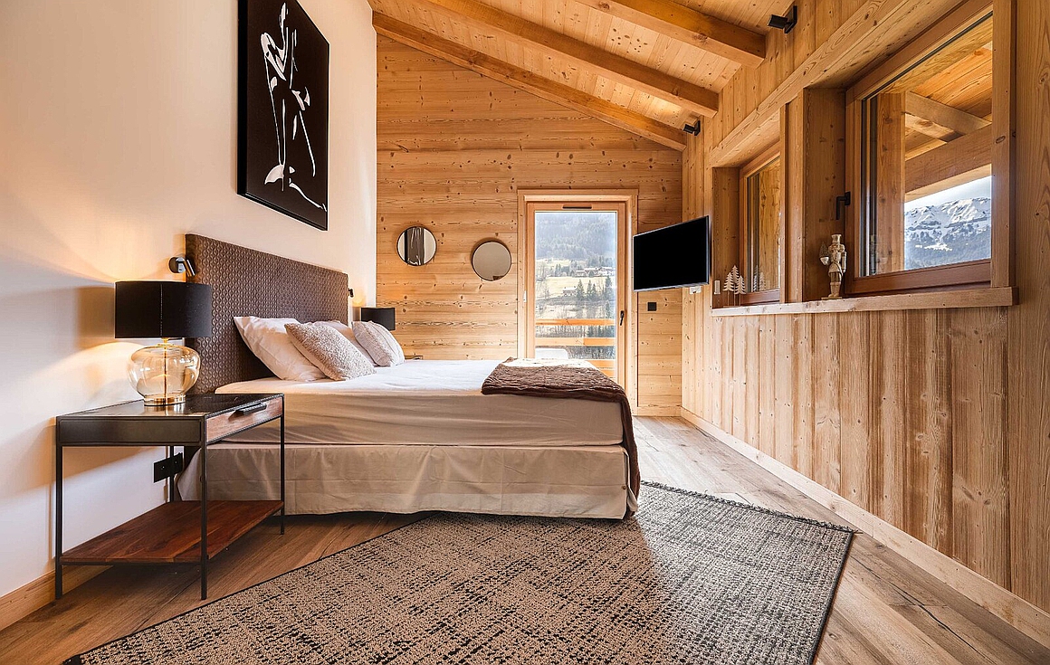 Sophisticated bedroom with natural wood design and alpine views